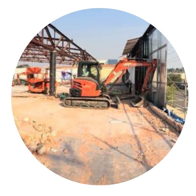 Commercial demolition in Newcastle with excavator dismantling building structure.