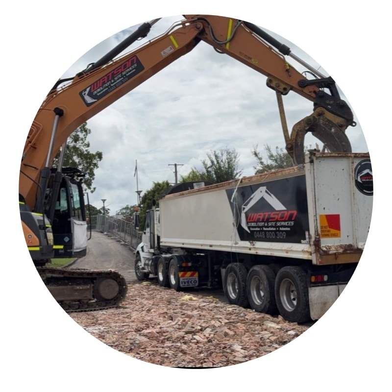 Top-rated demolition contractors loading rubble into truck with excavator in Newcastle NSW.